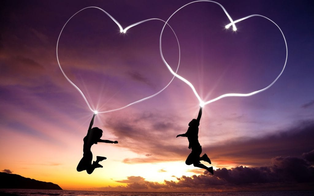 two people jumping with hearts